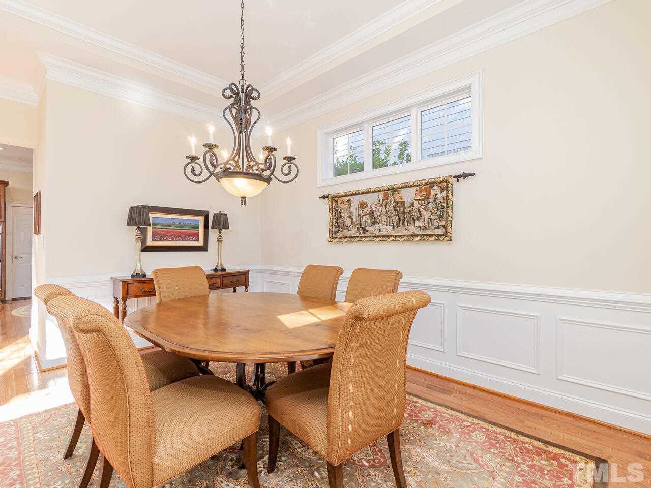 2267 Clayette Court Raleigh, NC 27612 - Photo 11 of 29 a view of a dining room with furniture a chandelier and wooden floor
