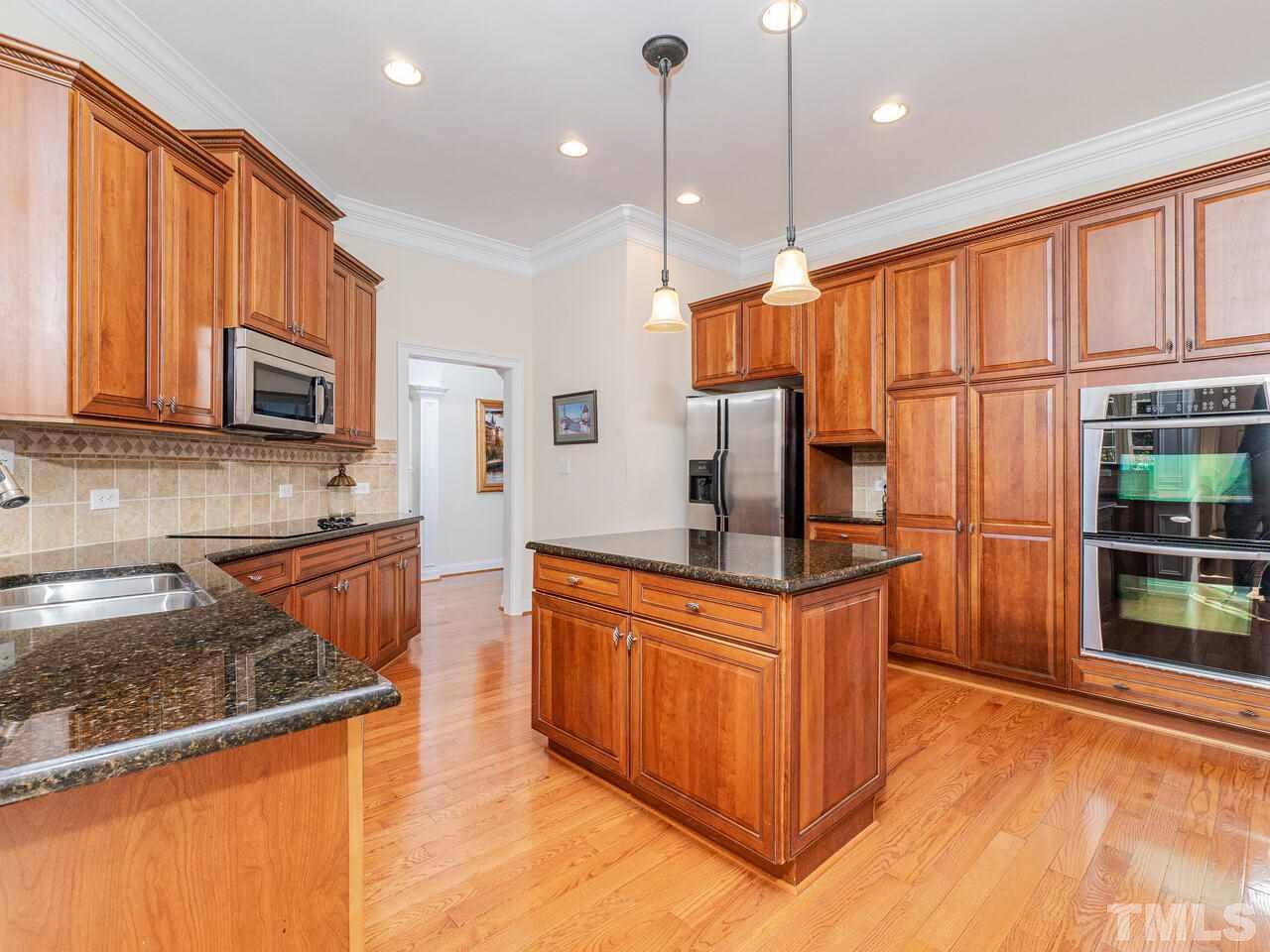 2267 Clayette Court Raleigh, NC 27612 - Photo 13 of 29 a kitchen with stainless steel appliances granite countertop a stove a sink and a microwave
