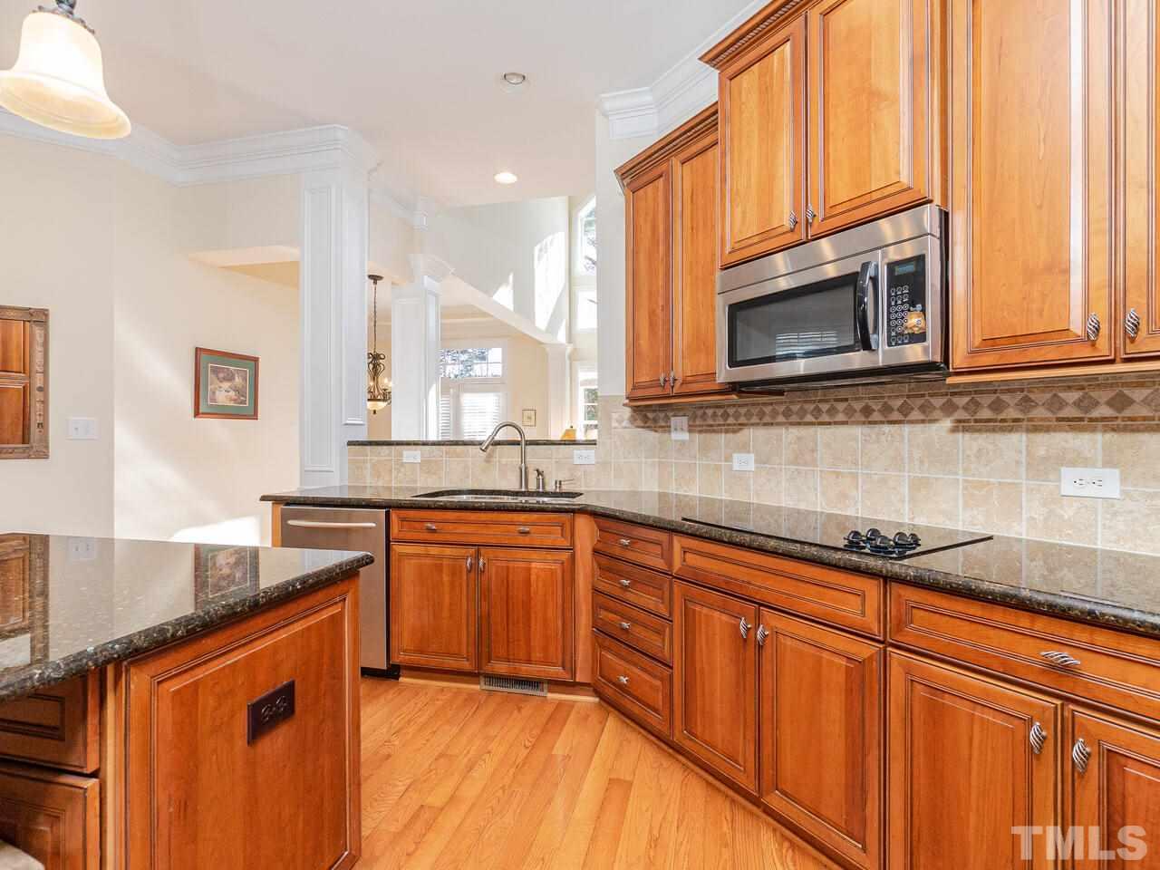 2267 Clayette Court Raleigh, NC 27612 - Photo 15 of 29 a kitchen with stainless steel appliances granite countertop wooden cabinets a sink and dishwasher