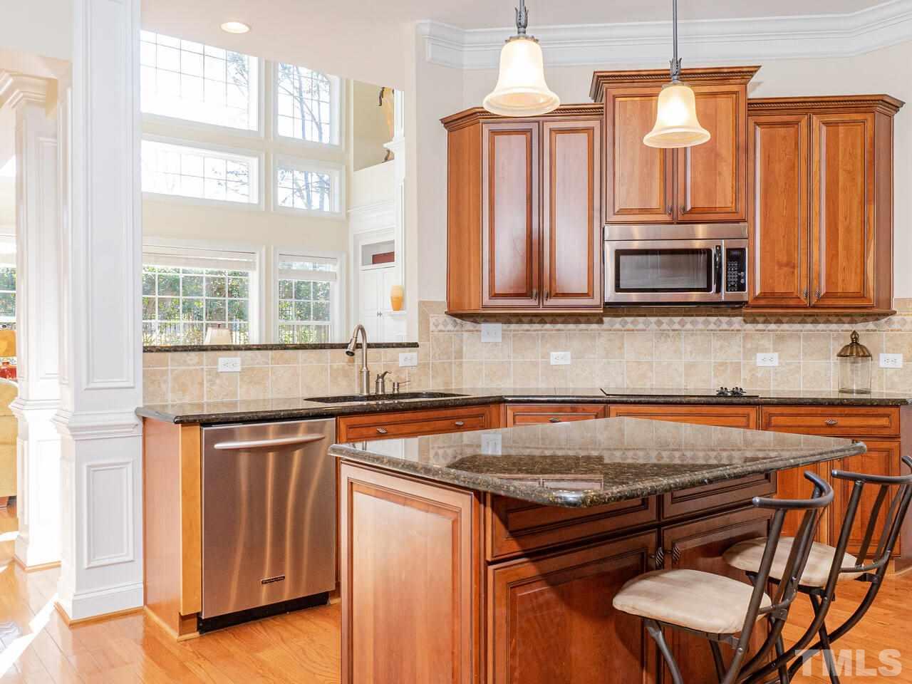 2267 Clayette Court Raleigh, NC 27612 - Photo 16 of 29 a kitchen with stainless steel appliances granite countertop a stove a sink and a microwave