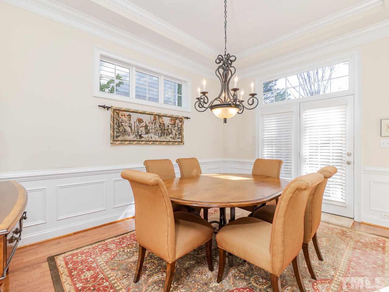 2267 Clayette Court Raleigh, NC 27612 - Photo 23 of 29 a view of a dining room with furniture a chandelier and wooden floor
