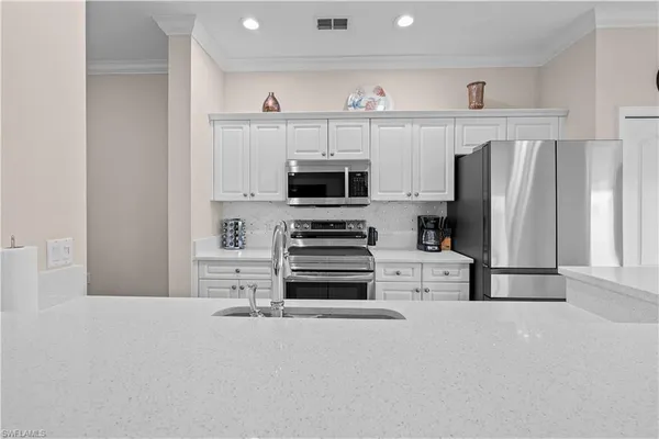 a kitchen with a refrigerator and a stove top oven