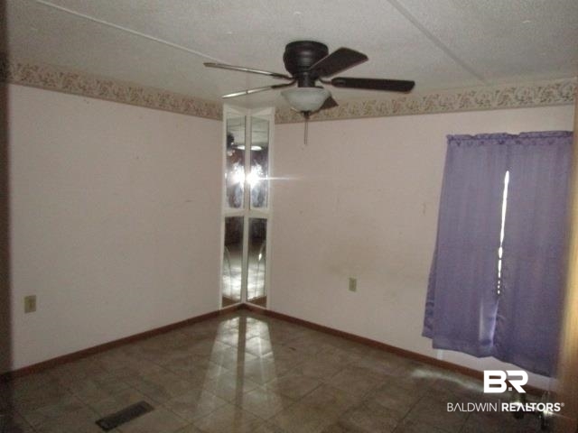 20705 Greek Cemetery Road Robertsdale, AL 36567 - Photo 17 of 25 Empty room with a textured ceiling and a ceiling fan