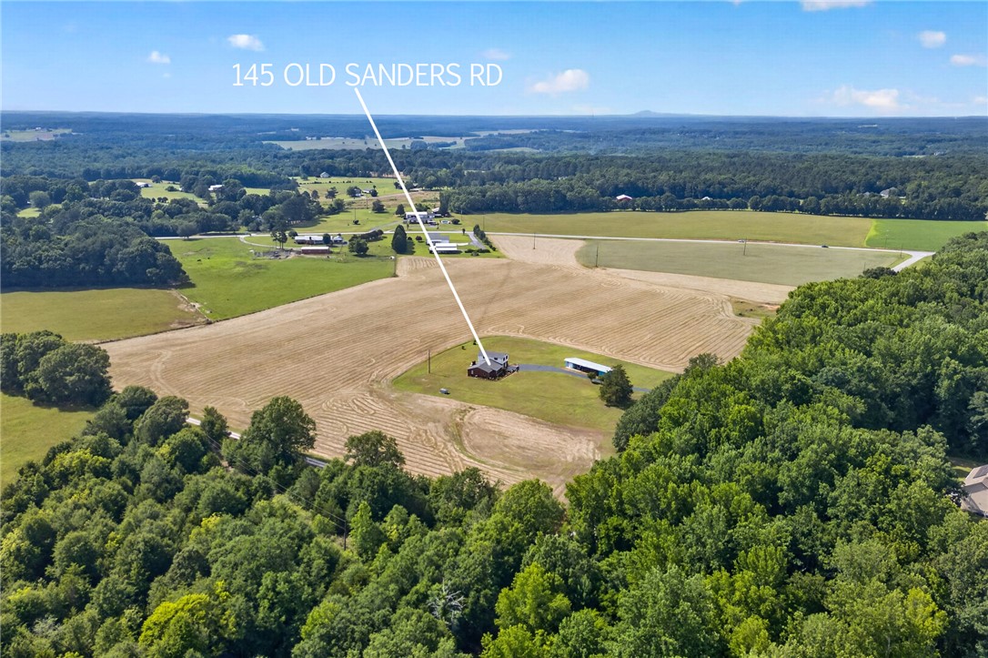 145 State Rd S-4-935 Pendleton, SC 29670 - Photo 25 of 47 Discover a private retreat nestled among verdant trees and open fields, offering serene rural views.