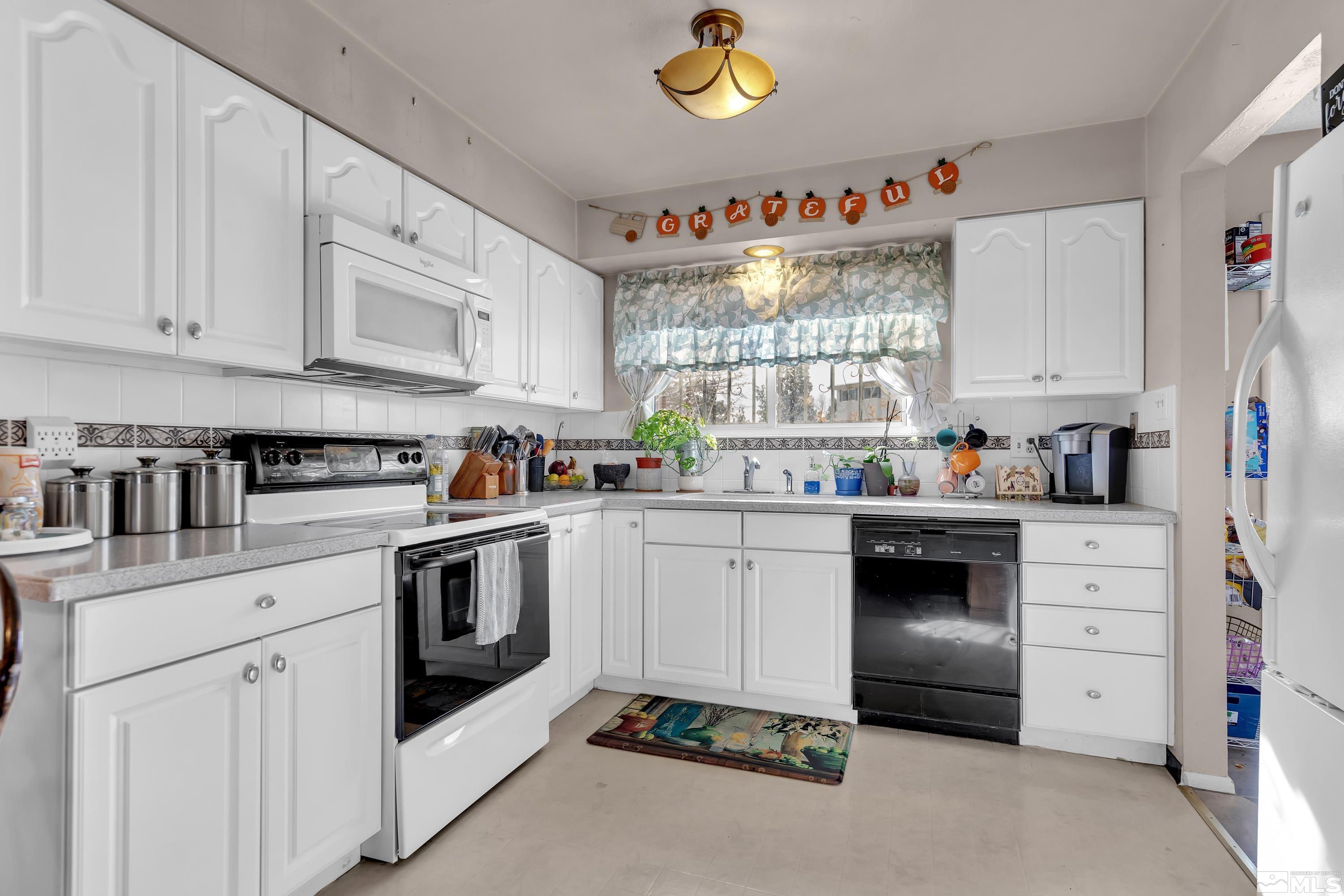 a kitchen with cabinets appliances and a window