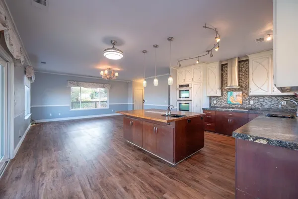 a kitchen with granite countertop a sink a stove and cabinets