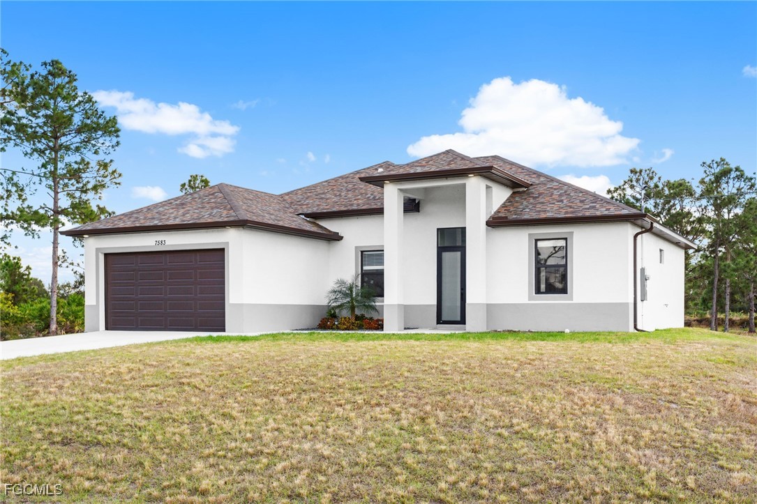 a front view of a house with a yard and garage