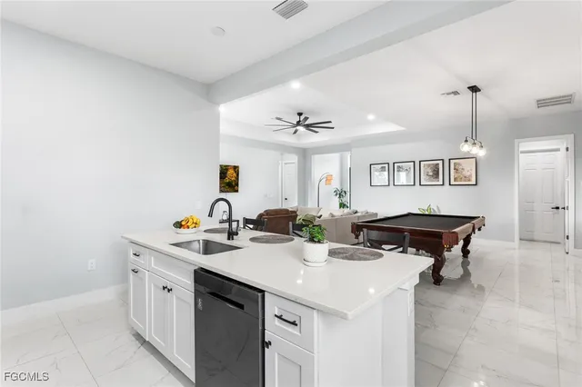 a kitchen with stainless steel appliances kitchen island granite countertop a table chairs and a refrigerator