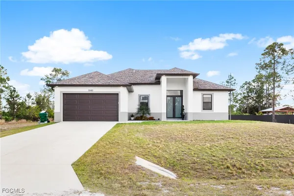 a front view of a house with a yard and garage