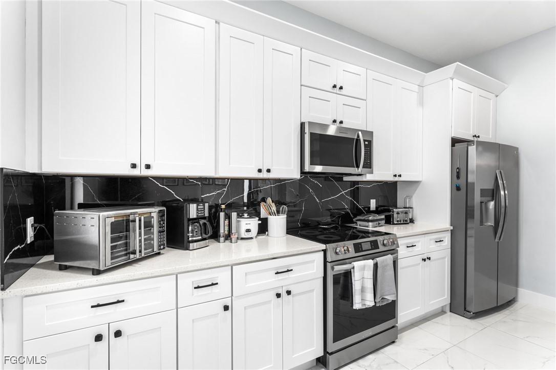 7583 15th Place LaBelle, FL 33935 - Photo 21 of 34 a kitchen with a refrigerator stove and sink
