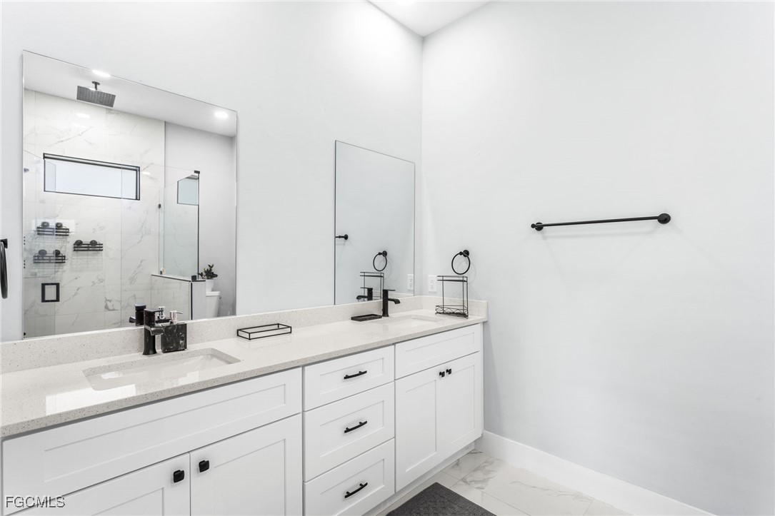 7583 15th Place LaBelle, FL 33935 - Photo 25 of 34 a bathroom with a double vanity sink a mirror and shower