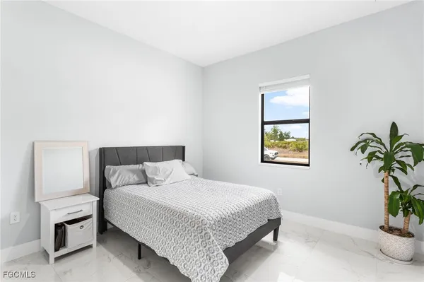 a bedroom with a bed and a potted plant