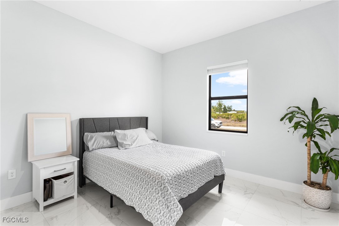 7583 15th Place LaBelle, FL 33935 - Photo 27 of 34 a bedroom with a bed and a potted plant