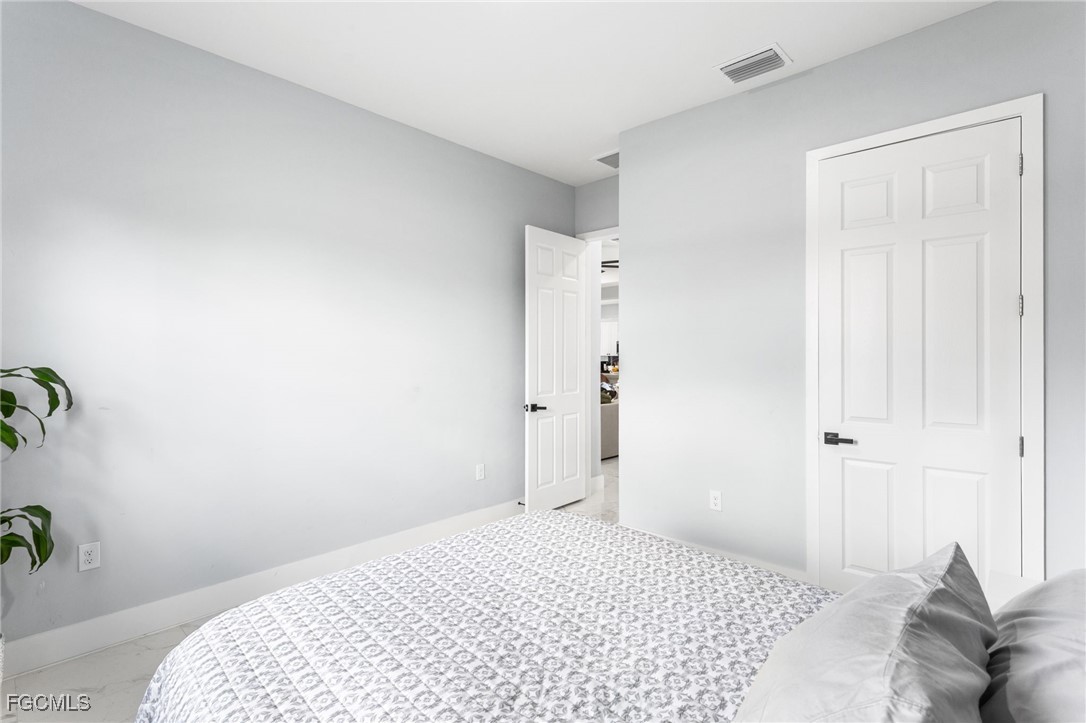 7583 15th Place LaBelle, FL 33935 - Photo 28 of 34 a bedroom with a bed and a potted plant