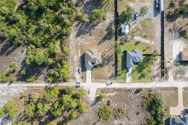 an aerial view of a house with a yard and large tree