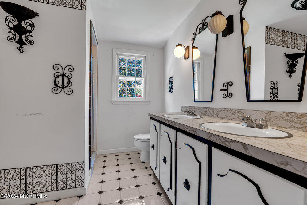 4 Cherry Place Manasquan, NJ 08736 - Photo 37 of 46 a bathroom with a sink a toilet and a mirror