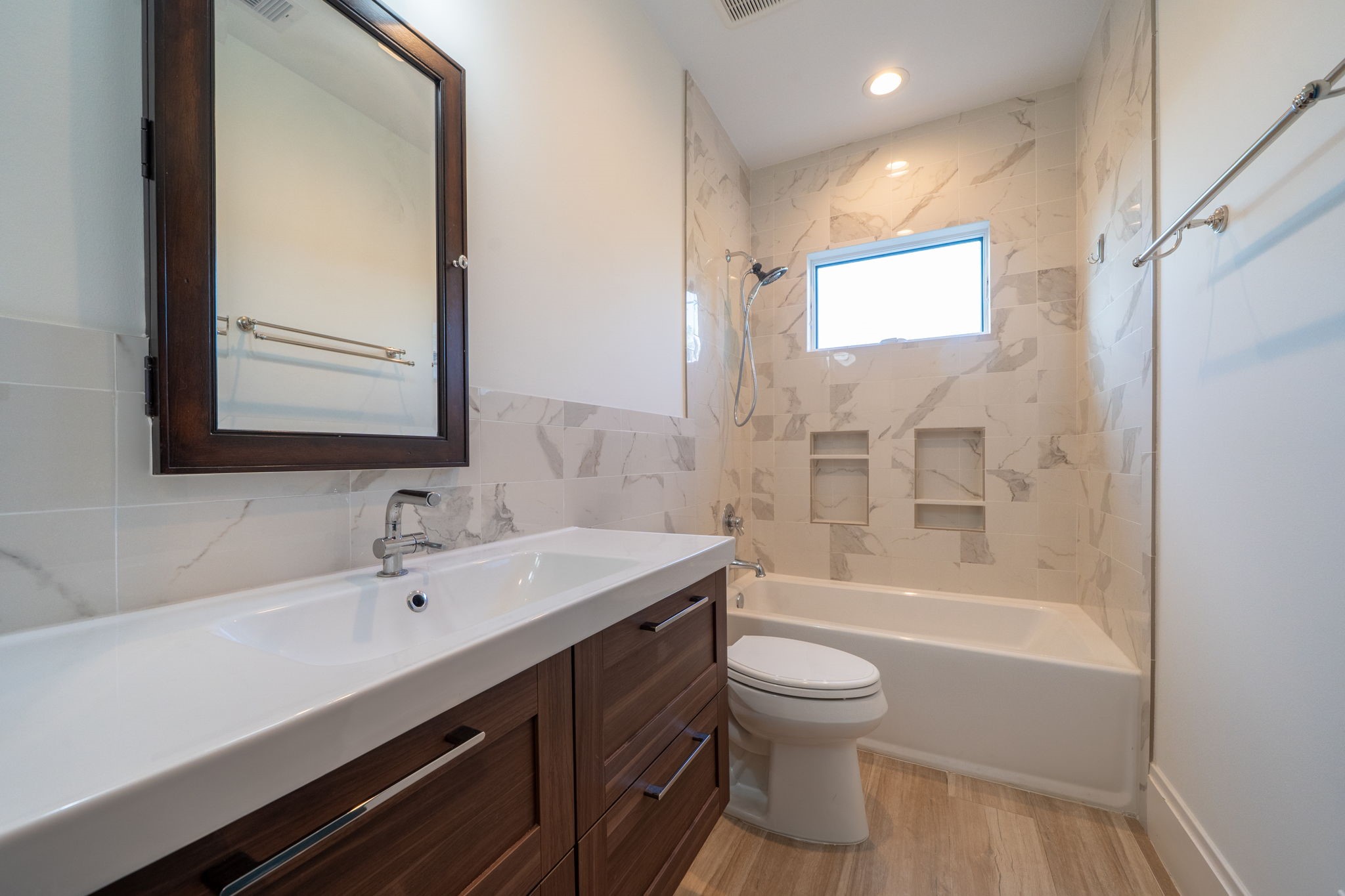 1109 Rutland Street Houston, TX 77008 - Photo 28 of 34 Step into this thoughtfully designed shared bathroom, where modern updates meet timeless elegance. The sleek, updated countertops provide both style and functionality, while the stunning tile surrounds add a touch of luxury, creating a serene and sophisticated space you'll love to unwind in.