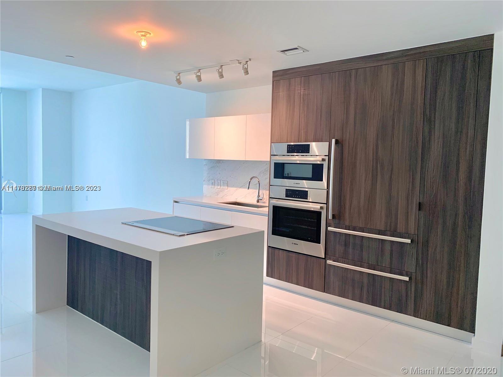 a kitchen with kitchen island a counter top space wooden floor and appliances
