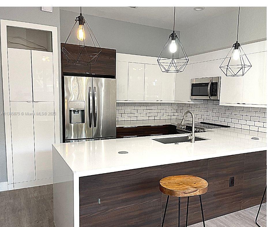 Cobblestone Pembroke Pines, FL 33027 - Photo 3 of 17 a kitchen with stainless steel appliances granite countertop a sink a stove a refrigerator and island
