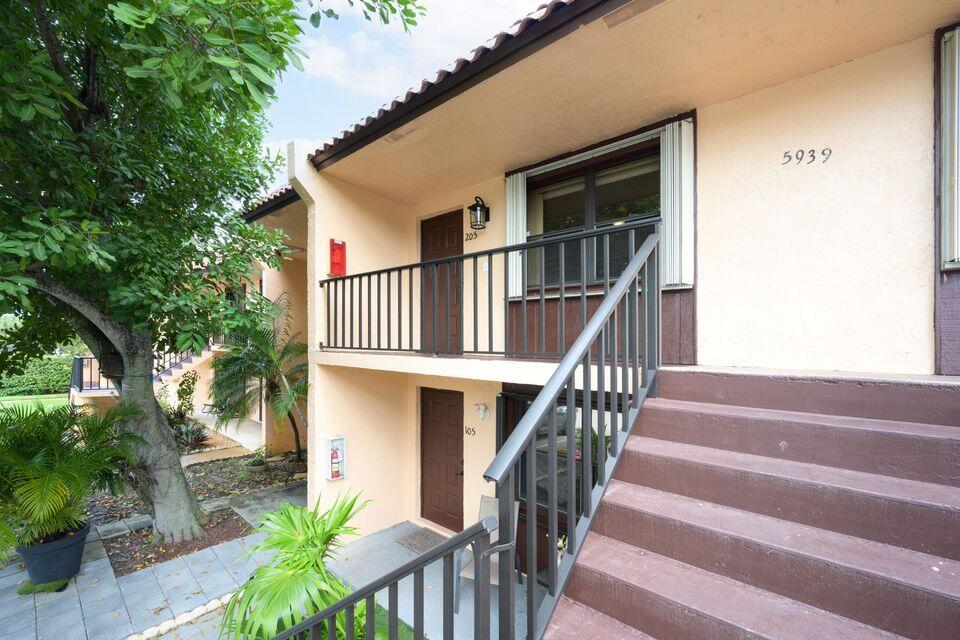 5939 Forest Hill Boulevard, Unit 205 West Palm Beach, FL 33415 - Photo 1 of 19 a front view of house along with deck and outdoor seating