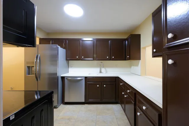 a kitchen with stainless steel appliances granite countertop a refrigerator a sink and a stove