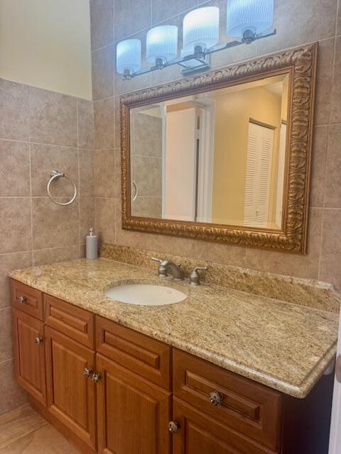 5939 Forest Hill Boulevard, Unit 205 West Palm Beach, FL 33415 - Photo 10 of 19 a bathroom with a granite countertop sink and a mirror