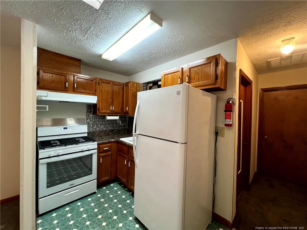 2472-2 John Hall Road Fayetteville, NC 28312 - Photo 5 of 10 a white refrigerator freezer and a stove sitting inside of a kitchen
