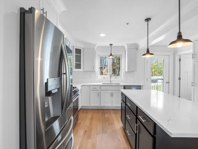 a kitchen with stainless steel appliances granite countertop a refrigerator a sink and a stove