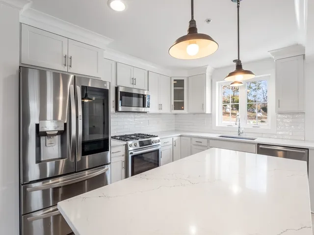 a kitchen with granite countertop a refrigerator oven a sink and dishwasher