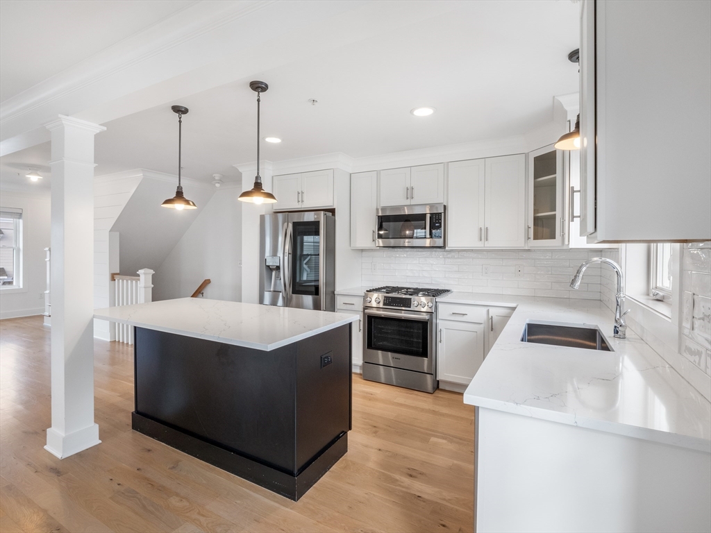 12 Hines, Unit 12 Newburyport, MA 01950 - Photo 14 of 32 a kitchen that has a lot of cabinets and stainless steel appliances