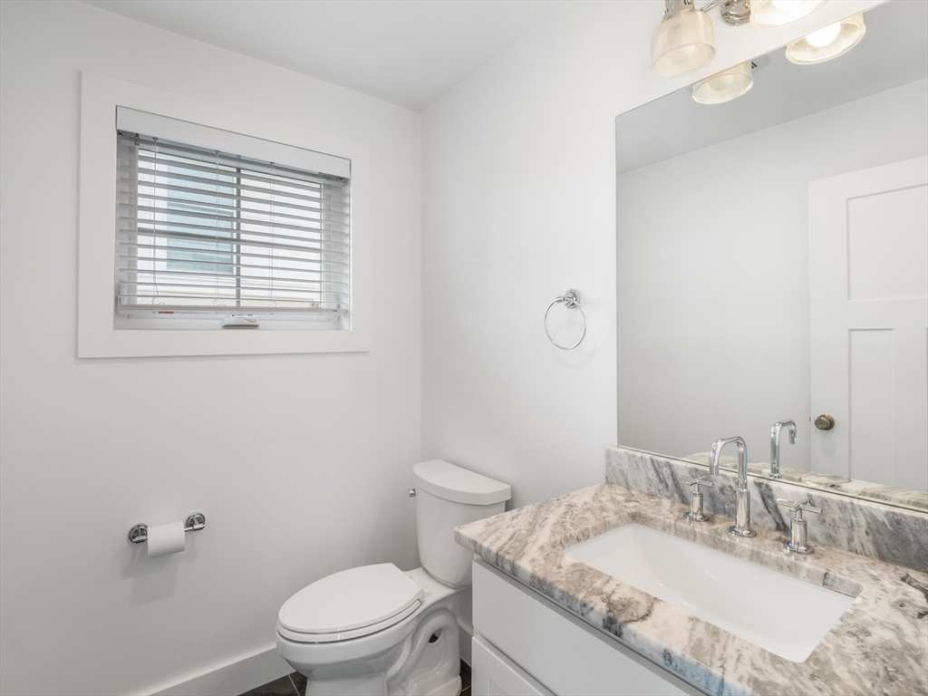 12 Hines, Unit 12 Newburyport, MA 01950 - Photo 15 of 32 a bathroom with a granite countertop sink a toilet and a mirror