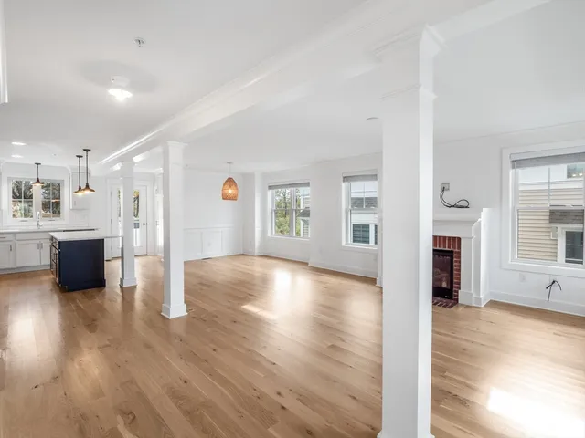 a view of a big room with wooden floor and windows