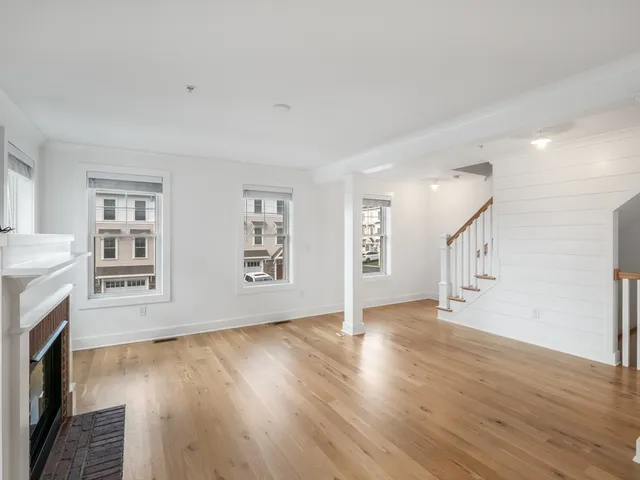 a view of empty room with wooden floor and fireplace