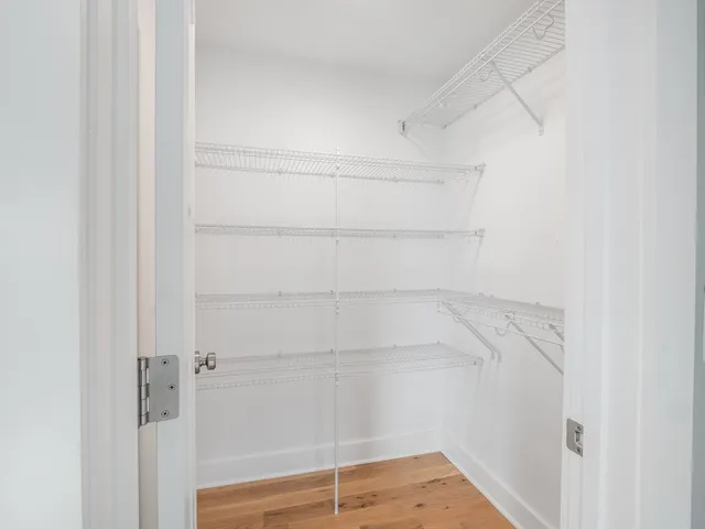 a view of walk in closet with empty racks