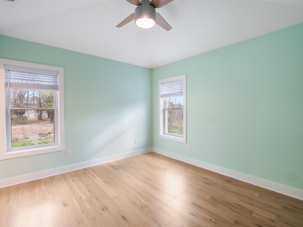 12 Hines, Unit 12 Newburyport, MA 01950 - Photo 30 of 32 a view of an empty room with a window and wooden floor