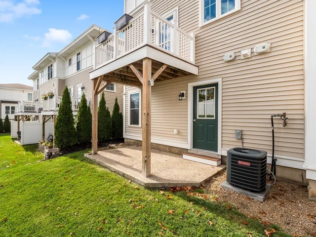 a view of a white house with a small yard and plants