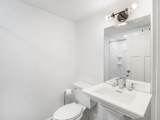 a bathroom with a sink a toilet and mirror