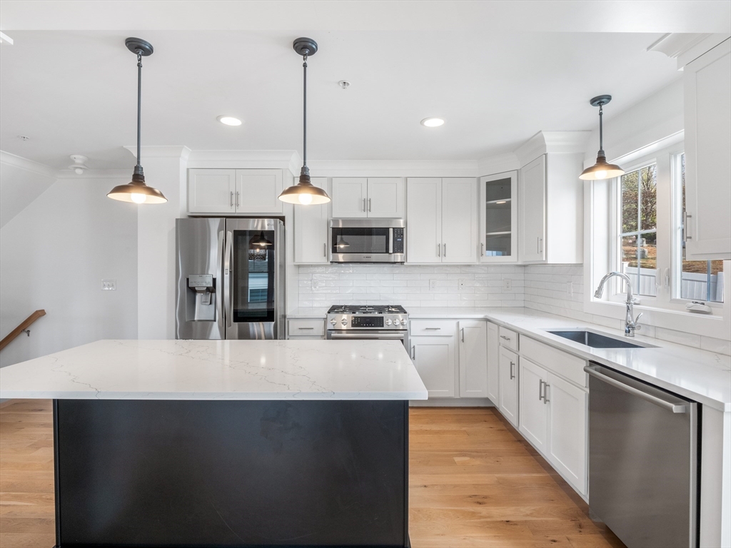 12 Hines, Unit 12 Newburyport, MA 01950 - Photo 10 of 32 a kitchen with stainless steel appliances granite countertop a sink a stove and a wooden floors