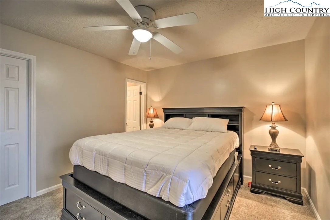 1664 Grouse Moor Drive, Unit 1 Sugar Mountain, NC 28604 - Photo 13 of 27 a bedroom with a bed and a chandelier