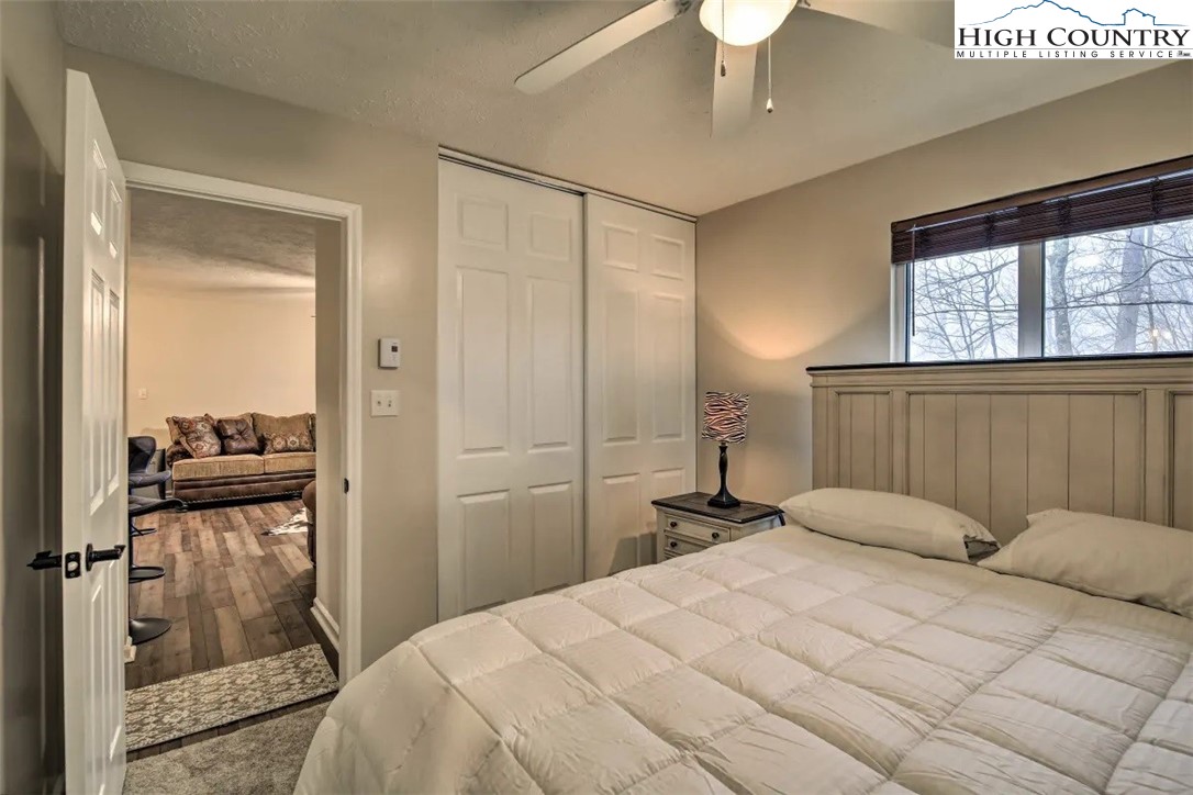 1664 Grouse Moor Drive, Unit 1 Sugar Mountain, NC 28604 - Photo 15 of 27 a bedroom with a bed and a chandelier