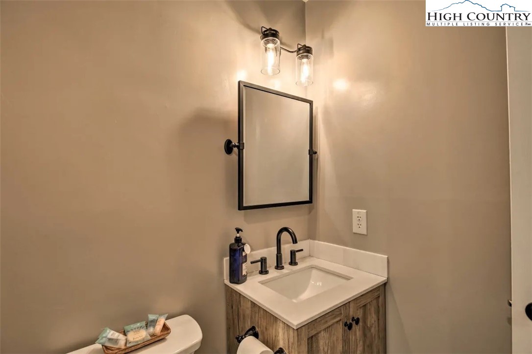 1664 Grouse Moor Drive, Unit 1 Sugar Mountain, NC 28604 - Photo 18 of 27 a bathroom with a sink mirror and toilet