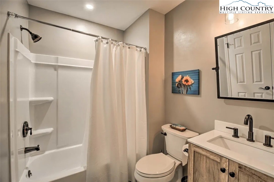 1664 Grouse Moor Drive, Unit 1 Sugar Mountain, NC 28604 - Photo 19 of 27 a bathroom with a sink a toilet and shower curtain