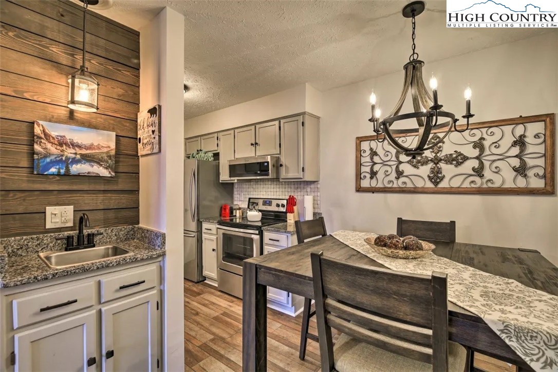 1664 Grouse Moor Drive, Unit 1 Sugar Mountain, NC 28604 - Photo 4 of 27 a kitchen with stainless steel appliances granite countertop a stove refrigerator sink and cabinets