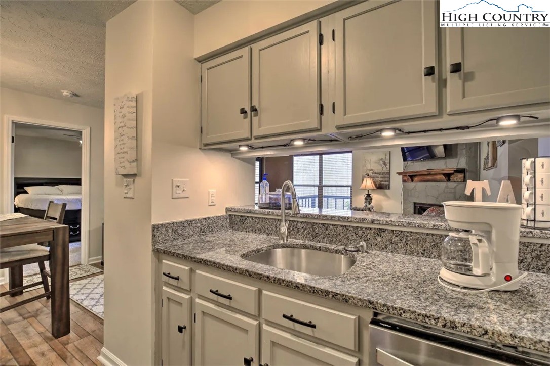 1664 Grouse Moor Drive, Unit 1 Sugar Mountain, NC 28604 - Photo 6 of 27 a kitchen with granite countertop a sink and cabinets