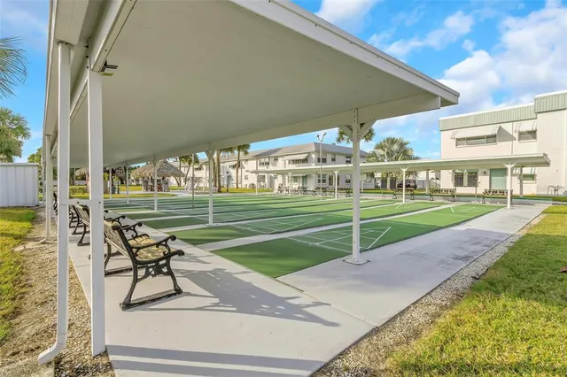 a view of a tennis ground with large trees