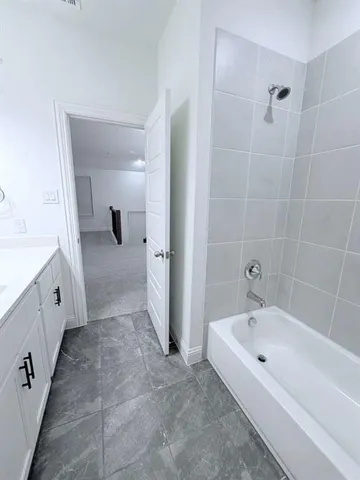 a spacious bathroom with a tub sink and mirror