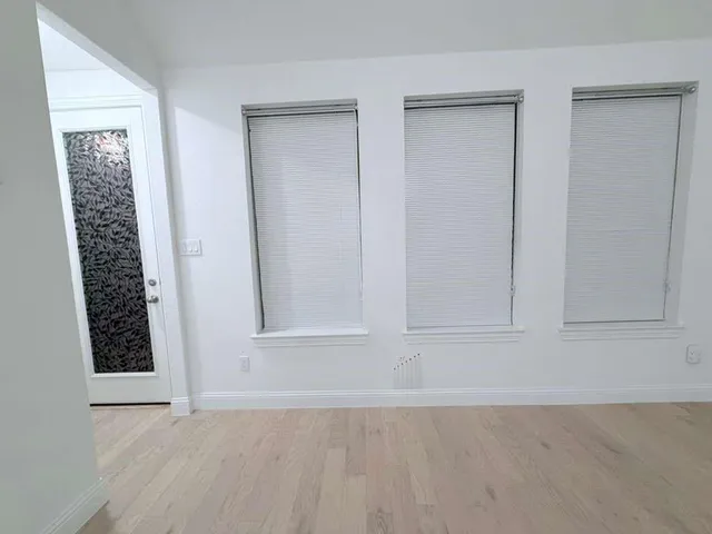 an empty room with a ceiling fan and wooden floor