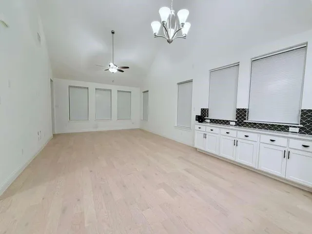a view of a kitchen with cabinets and chandelier