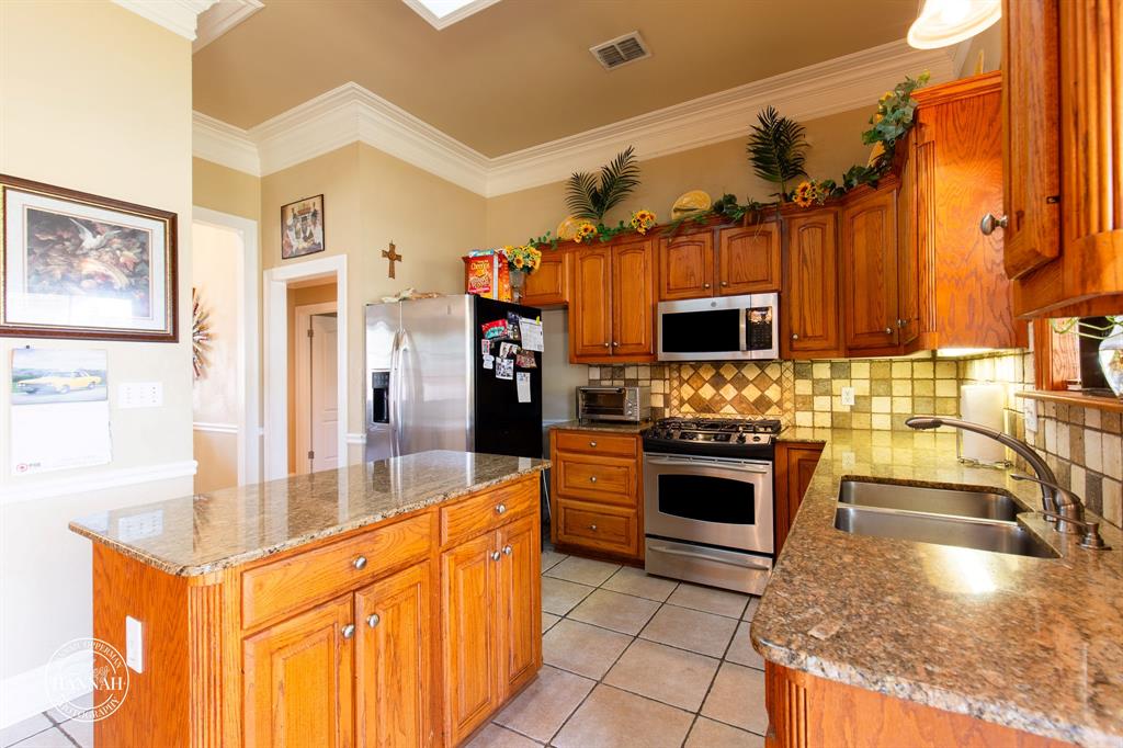 6531 North Liberty Way Keithville, LA 71047 - Photo 9 of 28 a kitchen with stainless steel appliances granite countertop a stove a sink and a microwave