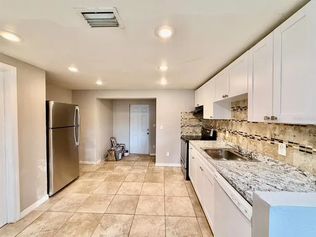 a kitchen with stainless steel appliances granite countertop a refrigerator and a sink